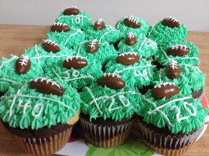 Marble cupcakes with green and white piped icing toped with a Tootsie Roll football.